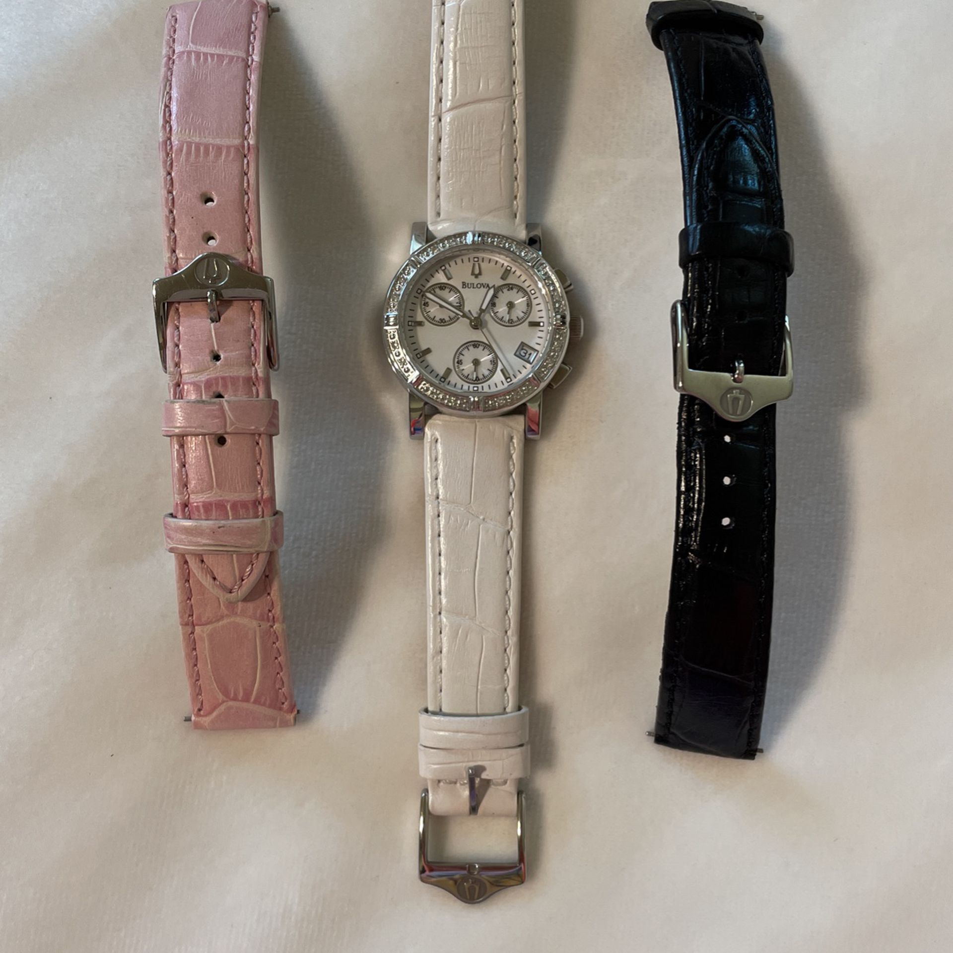 Bulova women’s watch with 3 leather straps. Only white has been used 2x.  white pink black and silver color dial. Has real diamonds