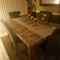 marble dining room table with 6 brown leather chairs
