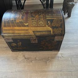 Vintage Chinese black lacquered storage trunk with hand-painted gold scenes.