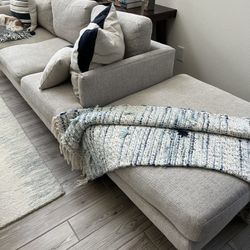 One Gray Couch, an Ottoman and Two Blue Swivel Chairs