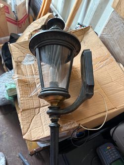 Traditional/Colonial Revival exterior wall-mount coach lantern sconce with clear glass panels, decorative finial with perforated collar, and turned lo