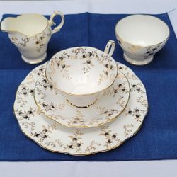 Vintage Queen Anne bone china tea set, in pattern number 5634, featuring a black and gold design.
