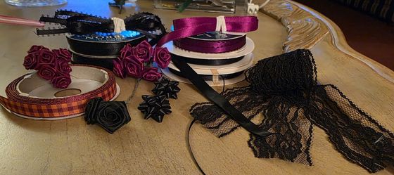 Black And Garnet Satin Ribbon Spools, Lace Strips, And Silk Flower Rosettes