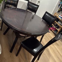 Dark Brown Circle Dining table And Cushioned chairs