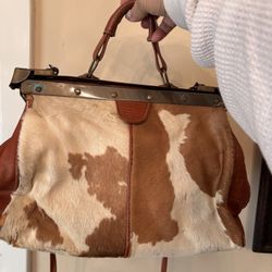 Cowhide and leather purse with shoulder strap has unique hardware has wear on both sides 