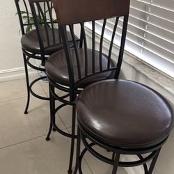 Three metal bar stools with leather swivel seats  in good condition
