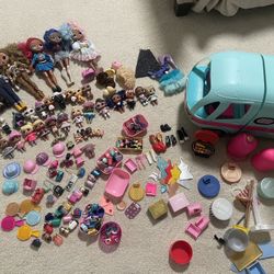 A large set of large and small LOL dolls and a camper car with a pool, lots of accessories.