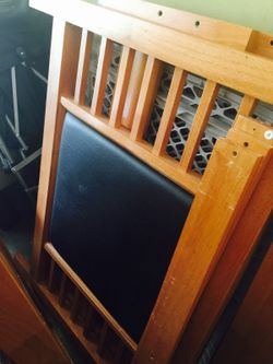 Twin wooden bed w/ brown leather on head and footboard.