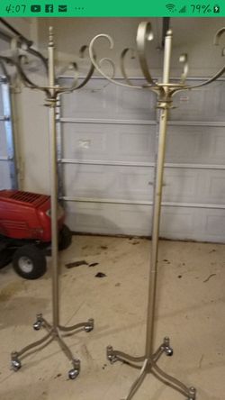 Two matching gold/bronze coat/clothes racks with rolling wheel on bottom