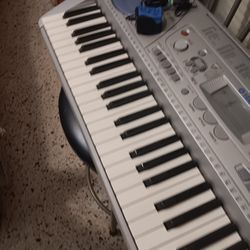 YAMAHA PIANO  MODEL PSR 275. WITH BENCH AND STAND.   WITH ADAPTER.  BUENA CONDICION 