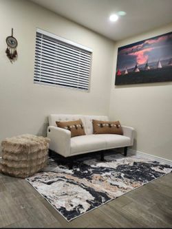 Futon couch with carpet & pillows.