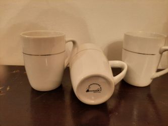 3 white cups with silver trim. Emerald