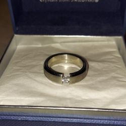 MEN'S BS STAINLESS STEEL WEDDING BAND CENTER OF BAND HAS SATIN FINISH WITH POLISHED BEVELED EDGES BAND HAS GAP WITH A CENTER 1/4 ct CZ STONE SIZE 12