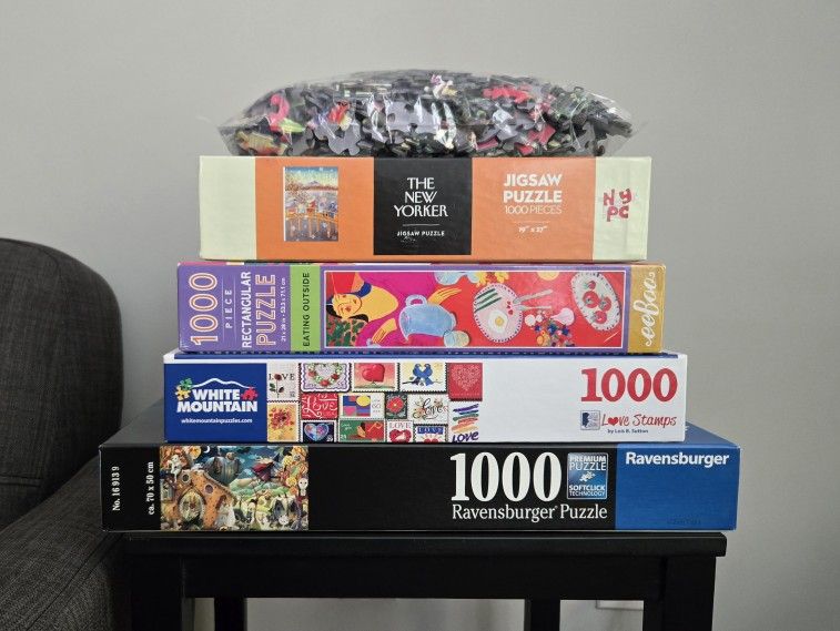 group of five 1000-piece puzzles