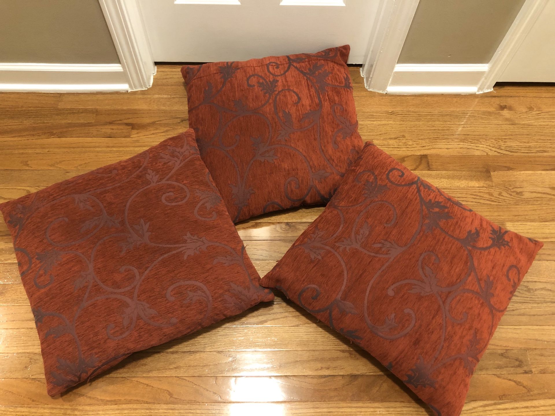 Set of 3 Throw Decorative Couch Pillows in a deep red color with Scroll leaf detail. Pillows are 21”x21” and in used condition. $5 for all 3 cash at