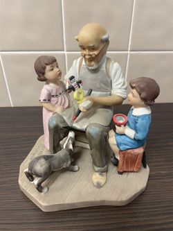 vintage Norman Rockwell figurine titled "The Toymaker". It is a limited edition porcelain figurine that depicts a grandfather with two grandchildren a