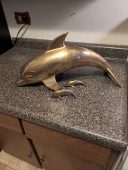 One large brass dolphin and 2 baby dolphins