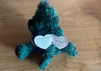 dark teal-green plush bear from the Ty Attic Treasures Collection named Laurel, identifiable by the heart-shaped paper tag reading "Happy Holly-days!"