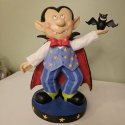 Decorative Halloween figurine of a vampire holding a bat