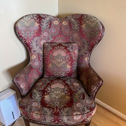 vintage Queen Anne style wingback armchair upholstered in a red patterned fabric