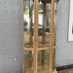 Curved display cabinet with light wood frame and curved glass panels. I can deliver for an additional cost