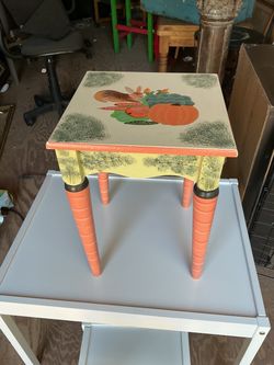 Hand-Painted Rabbit and Vegetable Accent Table with Carrot Legs it’s 16 inches tall and 12 by 12 inches across the top