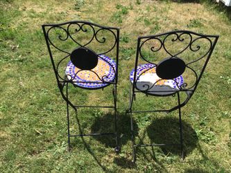 2 very heavy wrought iron bistro chairs. In need of a facelift. Need new tile. One needs a new bolt.