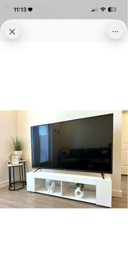 Español: Televisor de 65 pulgadas con mesa blanca. English: 65-inch TV with white TV stand.