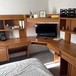 wooden home office desk with integrated storage and a hutch.