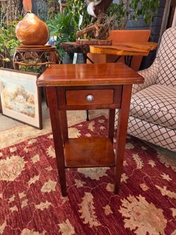 Wooden side table with tapered legs and an antique walnut finish.