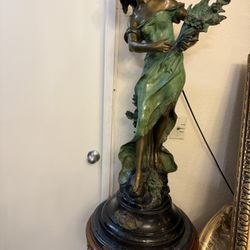 Patinated bronze sculpture on a round marble base. Dimensions: height 37.5 inches, width 14.5 inches, and base diameter 17 inches. Total weight approx