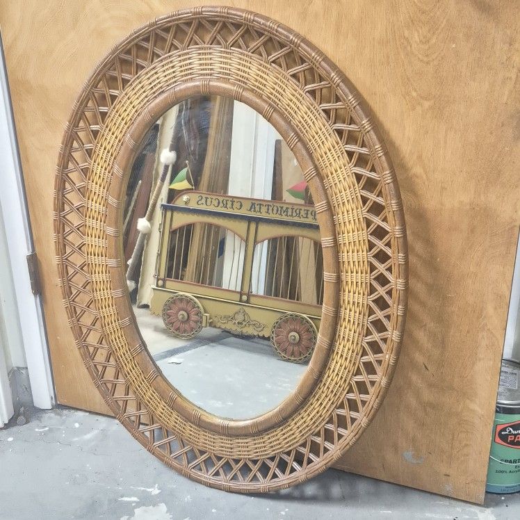 Vintage resin wicker mirror frame with Syroco oval mirror.34in. tall 26in. wide.