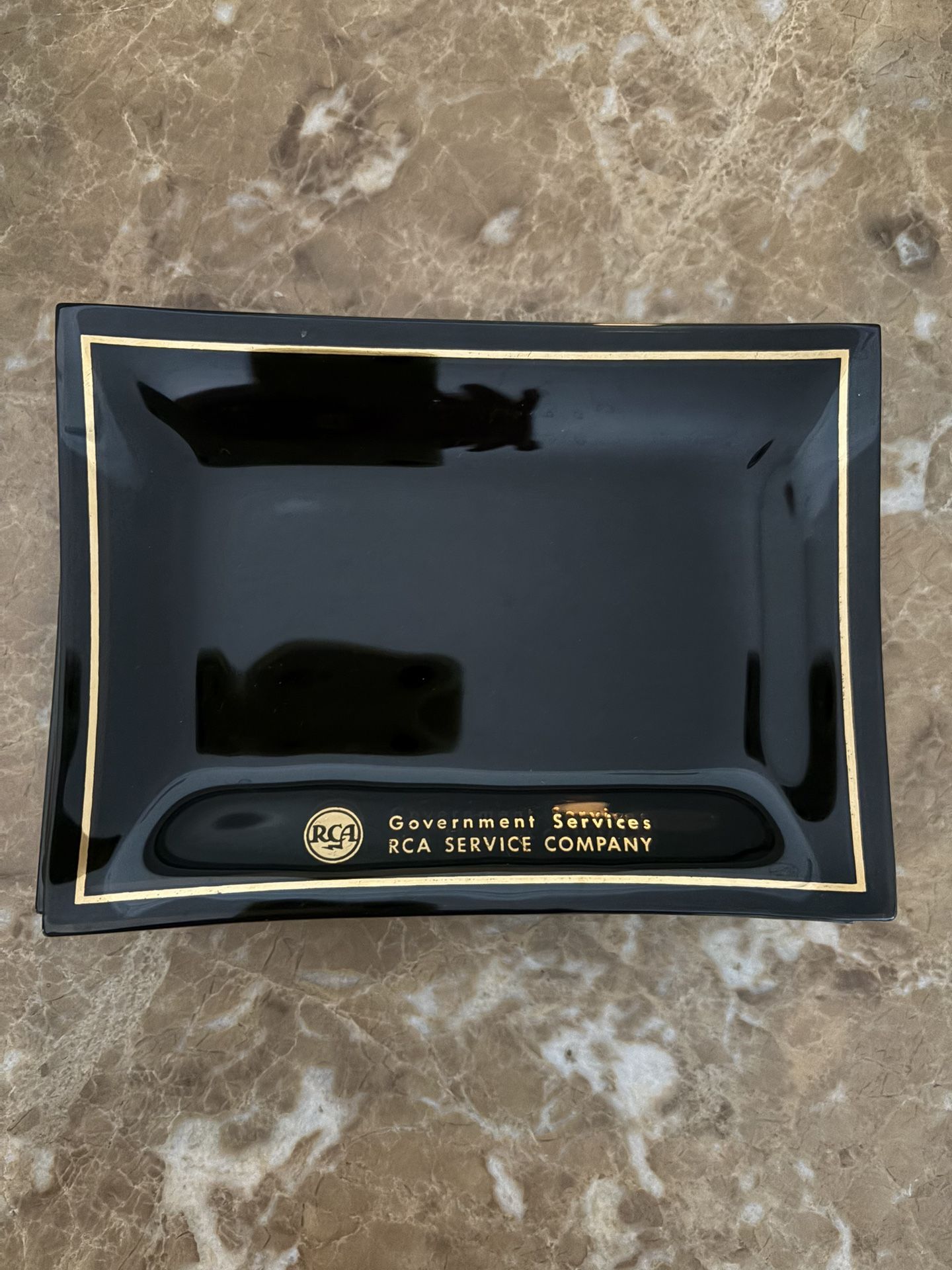 vintage 1960s RCA Government Services 7 plate or ashtray. It is a smoked glass item with gold trim and lettering.