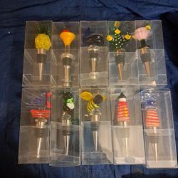 10 different decorative wine bottle stoppers featuring hand-blown or lampworked glass toppers