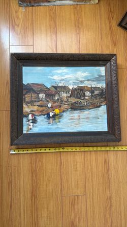 Original oil painting on canvas or board, depicting a rural riverside village scene with people washing clothes and a boat crossing the water.