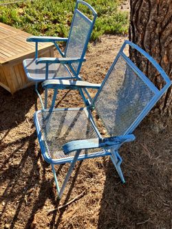 Two vintage blue metal outdoor folding patio chairs