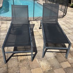 Two modern black pool lounge chairs