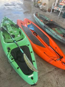 2 kayaks and a paddle board
