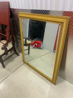Gold-framed wall mirror