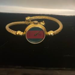 Vintage Stylish Gucci 2047 Swiss made bangle watch featuring a gold bracelet and bold red and green dial.