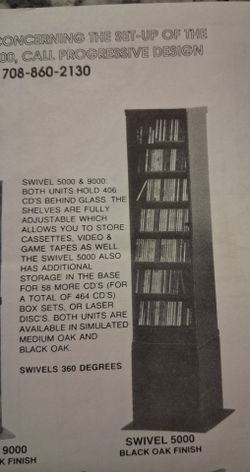 Game storage swivel cabinet with glass doors and base cabinet in black oak finish. With instruction manual.