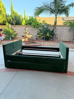 Mdern upholstered velvet platform bed with a hidden footboard storage drawer in dark/emerald green.
