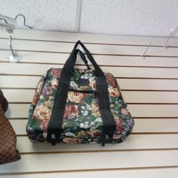vintage-style floral tapestry travel tote bag, similar to carpet bags or Singer sewing machine totes. 