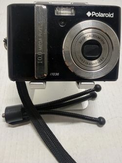 Polaroid Black Compact Camera with Silver Accents. Compact Polaroid digital camera. Front lens with silver trim. Built-in flash and simple controls. I
