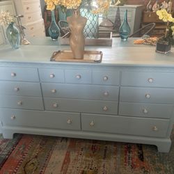 Blueish Dresser With Decorative Knobs 