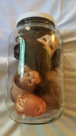 Vintage doll heads in a glass jar