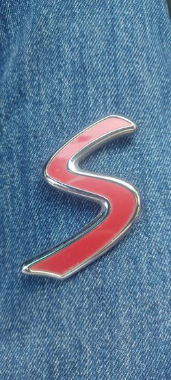 This is a MINI Cooper S red and chrome emblem sticker.