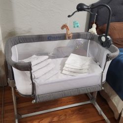 Optimisk bedside bassinet with extra covers.