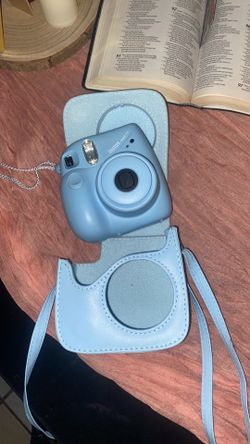 it is a Fujifilm Instax Mini 7S  which is a point-and-shoot instant film camera designed for simple,  photography.