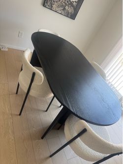 Black wooden table and four white sherpa chairs
